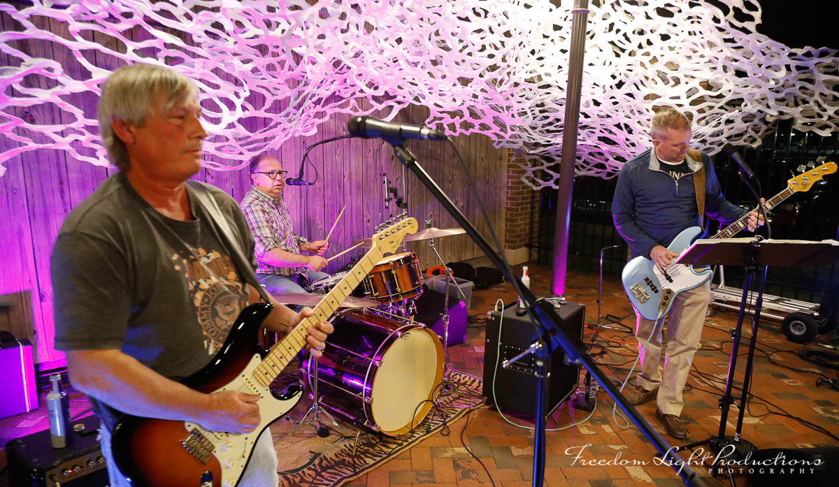 Musicians performing beneath a Jamey Grimes installation at River Clay Fine Arts Festival