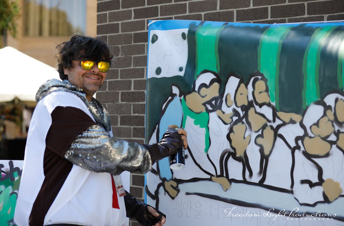 Chandler Hayes spray-painting his live mural at River Clay 2026