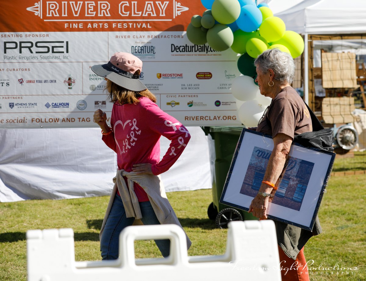 River Clay guests view framed artwork at the festival