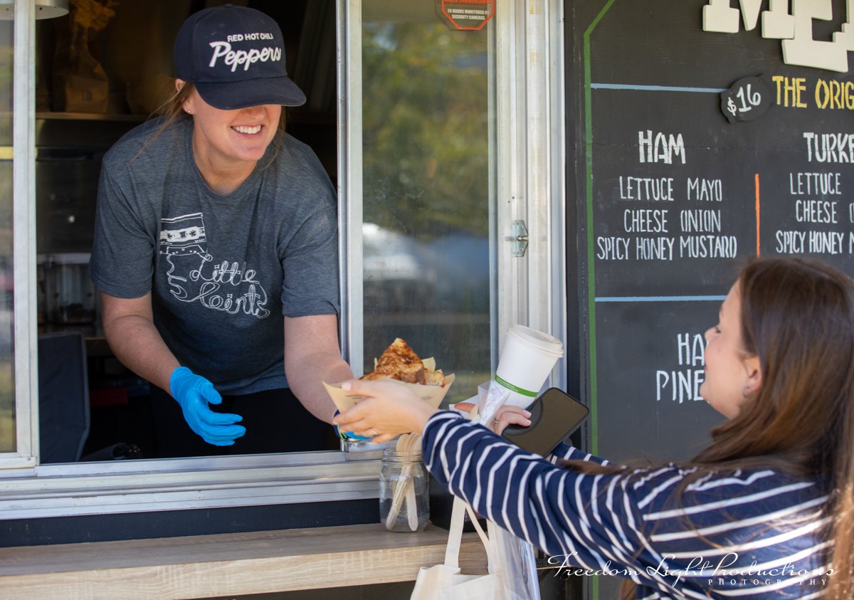 A food vendor serves a visitor at River Clay 2026